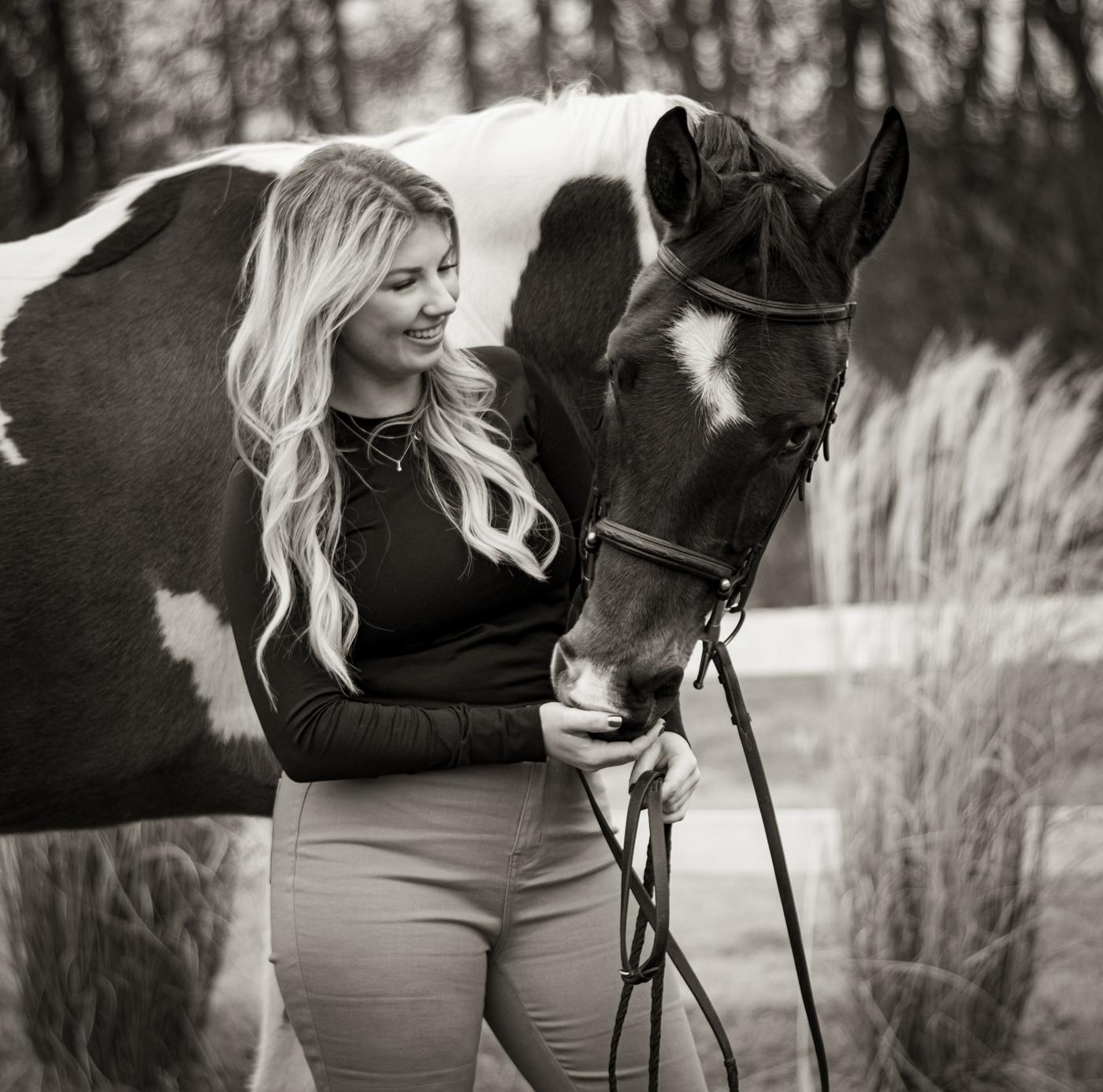 A rider and her paint horse, in black and white