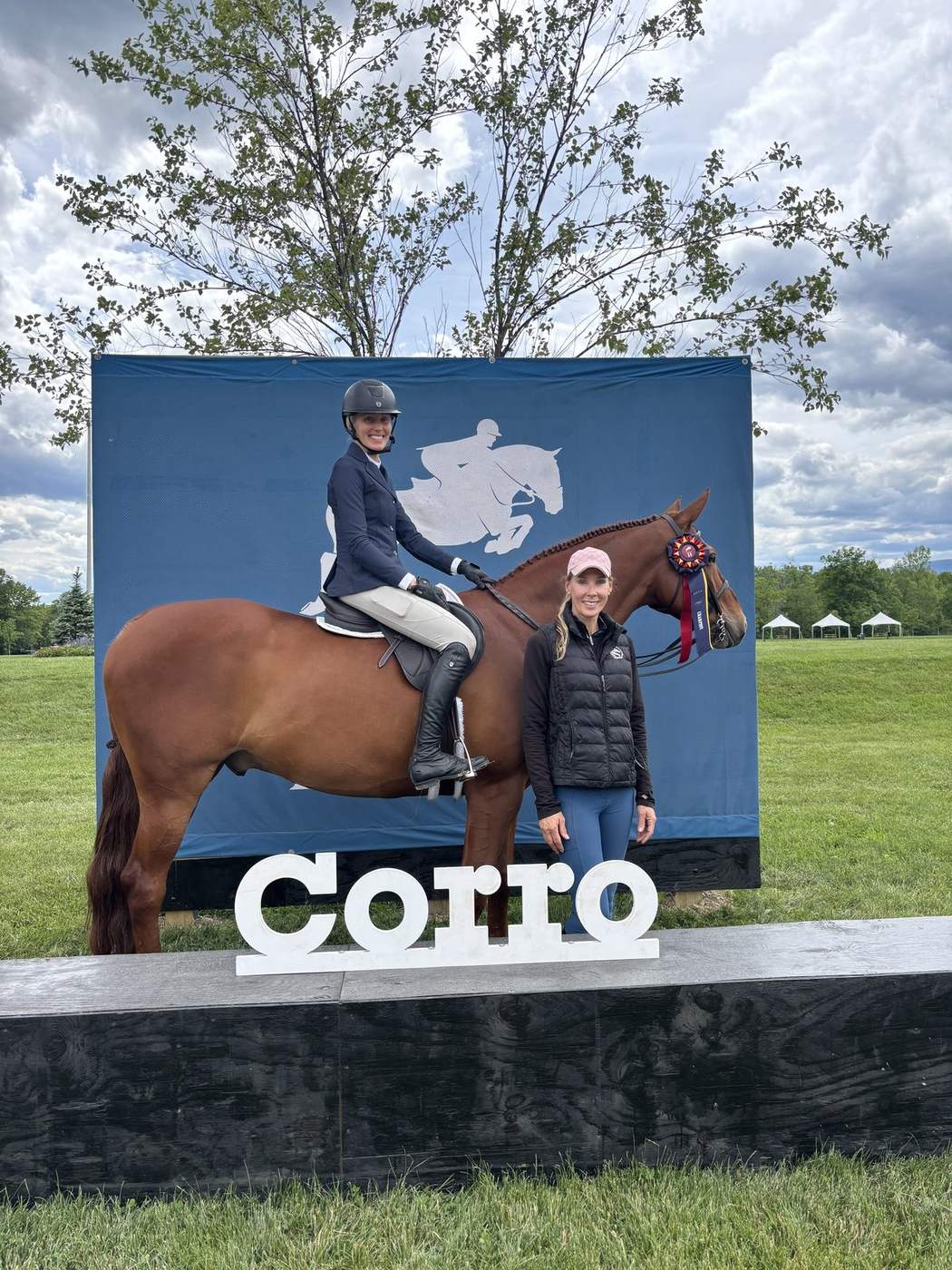 A rider and trainer with the horse after a championship