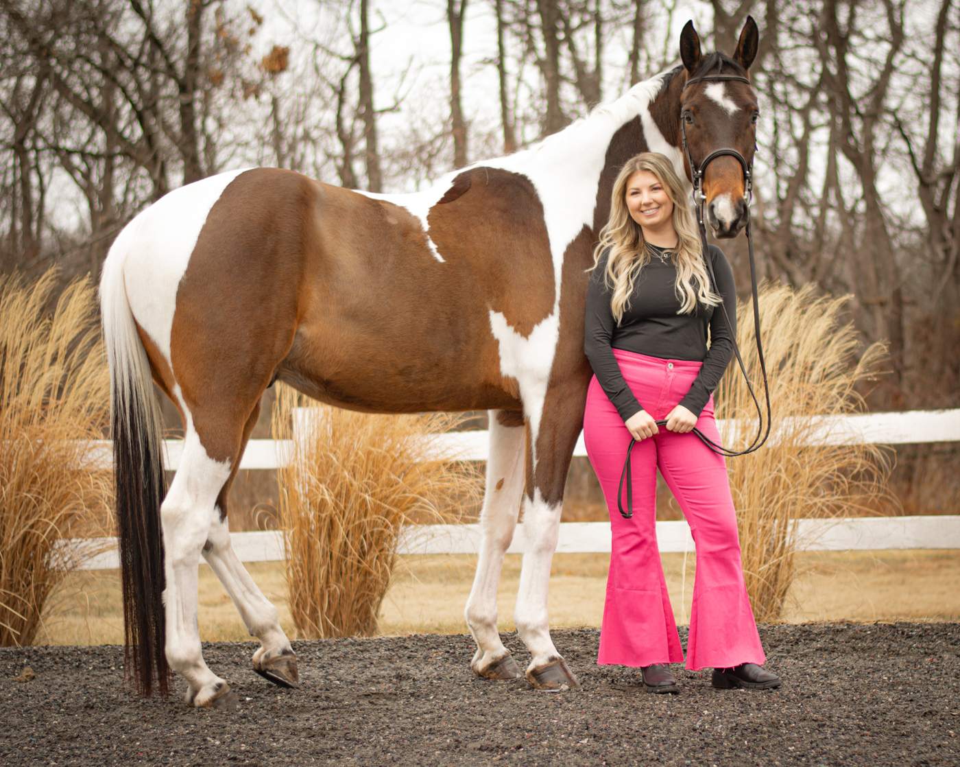 A rider with her paint horse on a winter afternoon