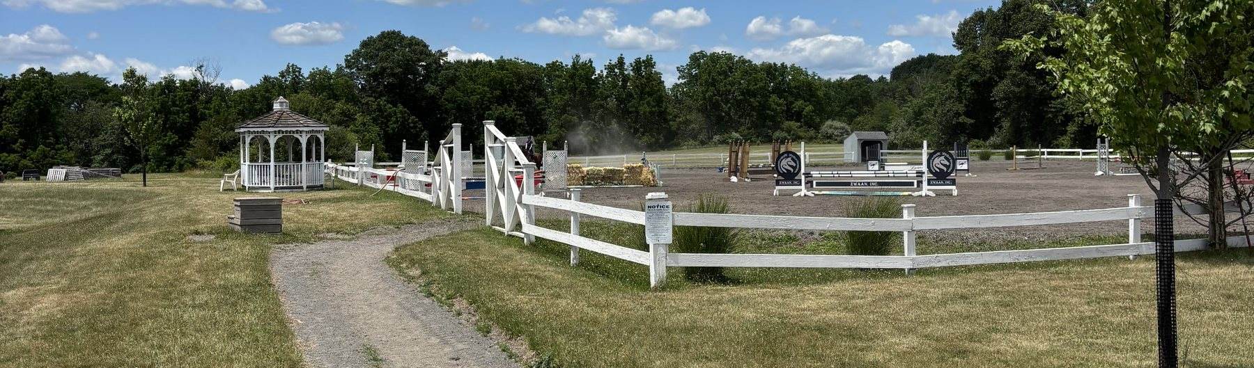 The outdoor arena set with a course of jumps at Lightfields Meadow Farm